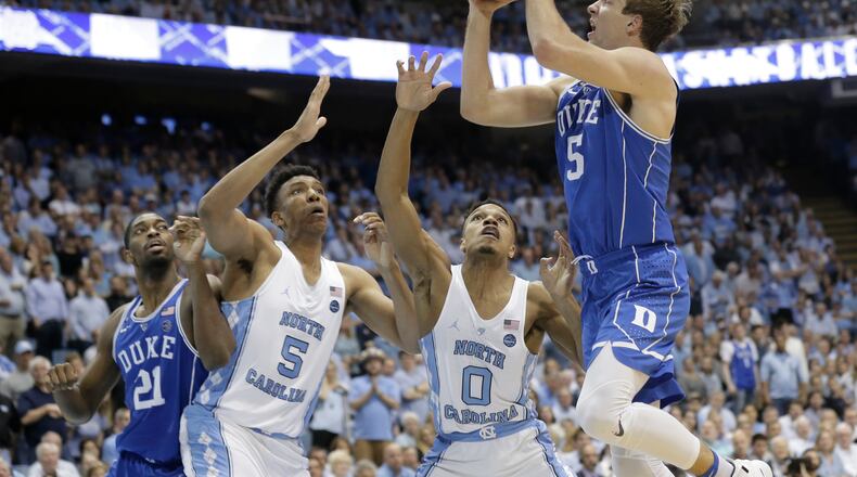 North Carolina’s Tony Bradley (5) and Nate Britt (0) defend against Duke’s Luke Kennard during the second half of an NCAA college basketball game in Chapel Hill, N.C., Saturday, March 4, 2017. North Carolina won 90-83. (AP Photo/Gerry Broome)