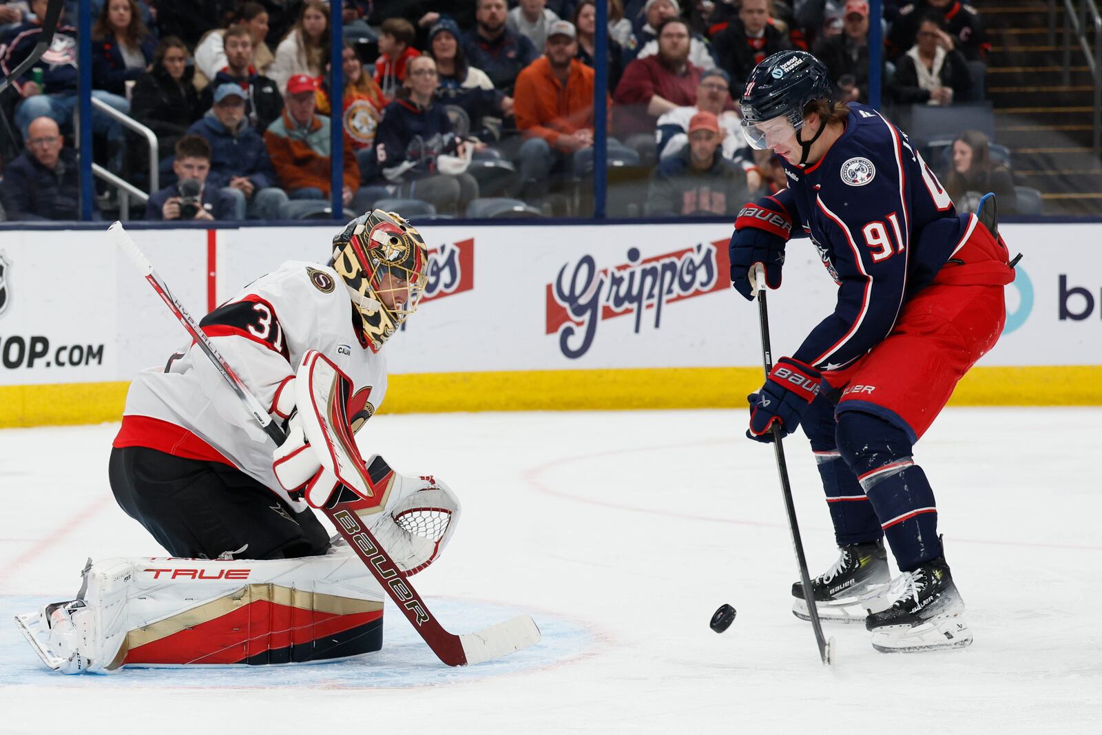 Ottawa Senators' Anton Forsberg, left, makes a save against Columbus Blue Jackets' Kent Johnson during the second period of an NHL hockey game Tuesday, April 8, 2025, in Columbus, Ohio. (AP Photo/Jay LaPrete)