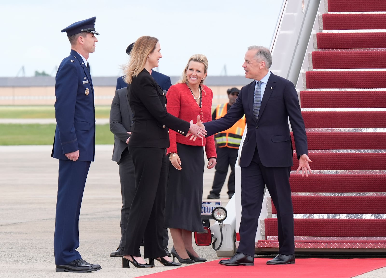Canada's Prime Minister Mark Carney, right, is greeted by Canadian Ambassador to the U.S. Kirsten Hillman, second left, U.S. Acting Chief of Protocol Abby Jones, and U.S. Col. Randall J. Heusser after he disembarks a government plane Monday, May 5, 2025, as he arrives in Washington. (Adrian Wyld/The Canadian Press via AP)