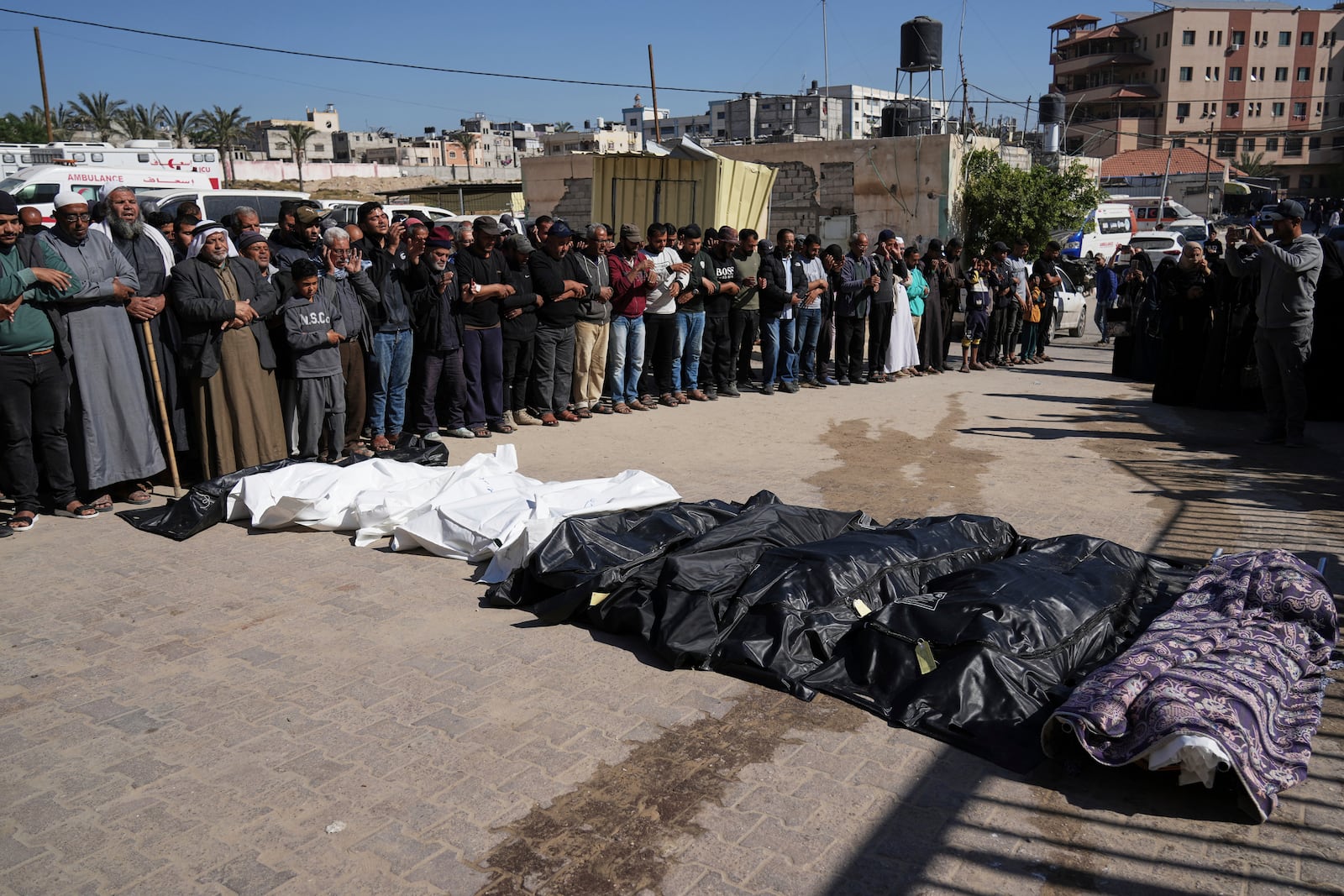 Mourners pray over the bodies of 10 members of the Abu Al-Rous family, killed when an Israeli airstrike struck their displacement tent overnight, during their funeral in Khan Younis, southern Gaza Strip, Thursday, April 17, 2025. (AP Photo/Abdel Kareem Hana)