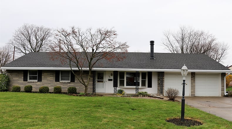 The stone-and-brick ranch has about 1,720 sq. ft. of living space. The 4-bedroom home sits on an irregular lot with a chain-link fence surrounding the back yard. A long concrete driveway leads to a 2-car, attached garage. CONTRIBUTED PHOTO BY KATHY TYLER