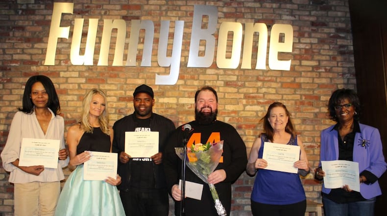 Tim Loulies, holding the flowers, is the head instructor for the Funny Bone Comedy School. He is seen here with the spring Liberty Funny Bone Comedy School graduates. CONTRIBUTED