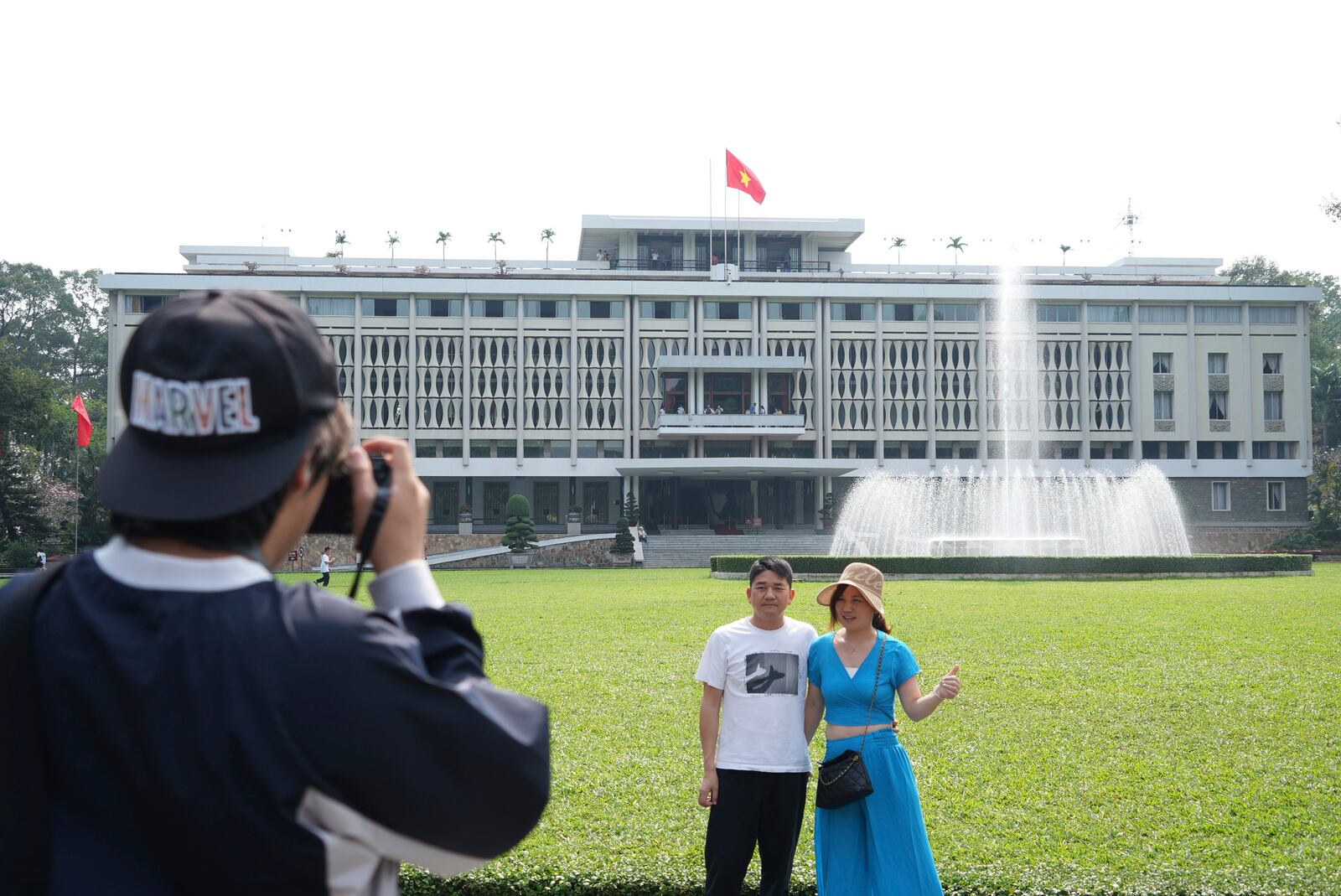 Tourists pose for photos in front of Independence Palace in Ho Chi Minh City, Vietnam, Feb. 20, 2025. (AP Photo/Hau Dinh)