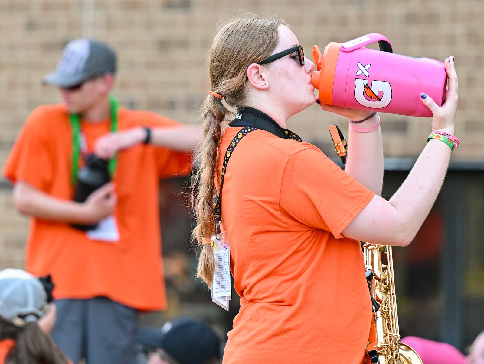 A Beavercreek High School band member drinks water during a break on Tuesday, July 29. The program is hosting its camp all week long. On Tuesday, the band practiced in early morning and later evening to avoid mid-day heat. BRYANT BILLING / STAFF