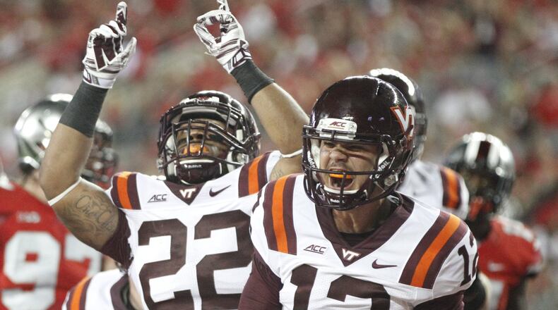 Virginia Tech’s Michael Brewer (12) and Shai McKenzie celebrate a touchdown by McKenzie in the first half on Saturday, Sept. 6, 2014, at Ohio Stadium in Columbus. David Jablonski/Staff