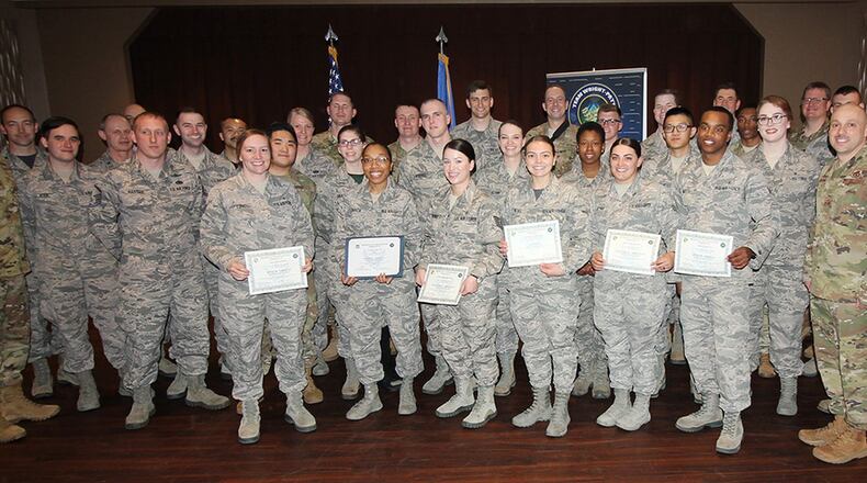 Col. Thomas Sherman (left), 88th Air Base Wing and installation commander, and Chief Master Sgt. Stephen Arbona (right), 88th Air Base Wing command chief, stand with the newest Team Wright-Patt enlisted promotees during a ceremony at the Wright-Patterson Club March 29. (U.S. Air Force photo/Thomas Lewis)
