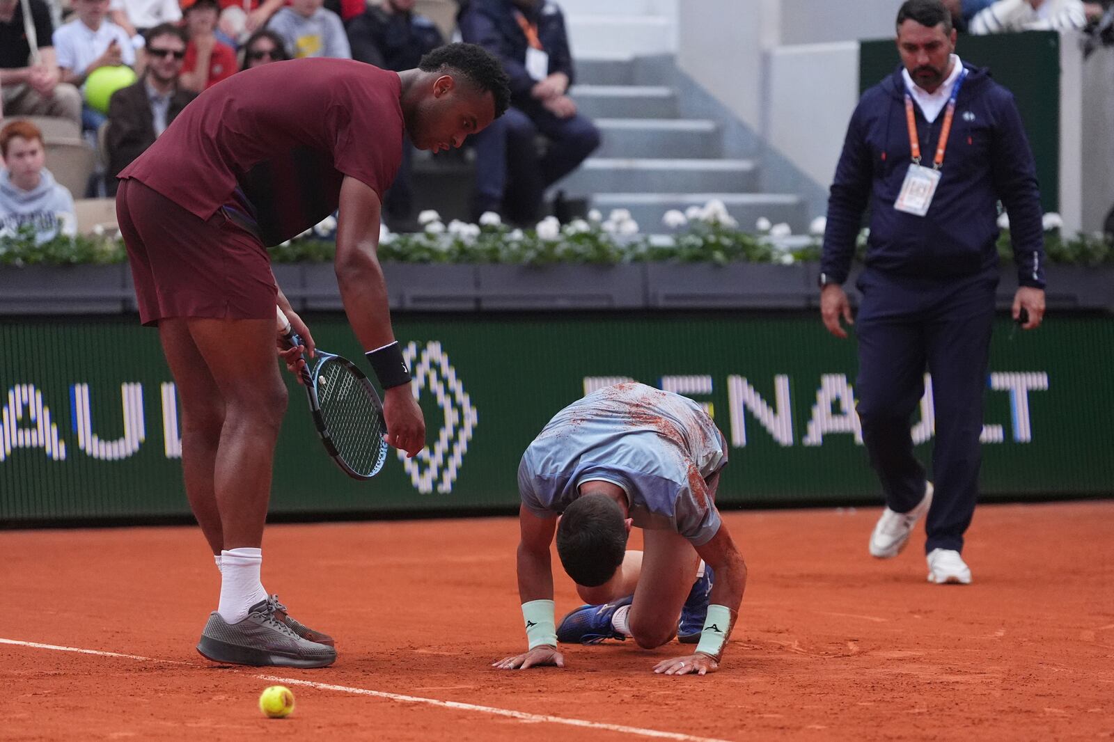 France's Giovanni Mpetshi Perricard, left, looks at Bosnia and Herzegovina's Damir Dzumhur lying on the court after falling, during their second round match of the French Tennis Open, at the Roland-Garros stadium, in Paris, Wednesday, May 28, 2025. (AP Photo/Lindsey Wasson)