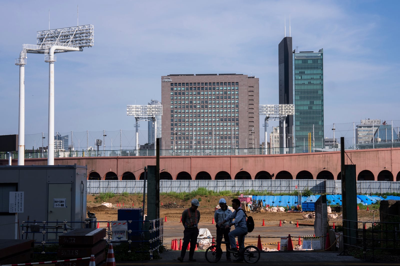 Workers at a construction site near the Jingu stadium in Tokyo, Wednesday, July 3, 2025. (AP Photo/Louise Delmotte)