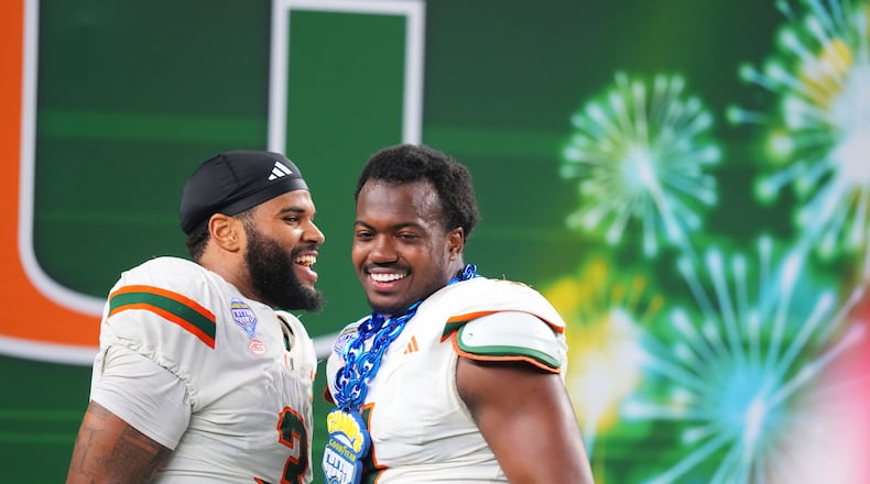 Miami defensive lineman Akheem Mesidor, left, and defensive lineman Rueben Bain Jr. react following the Cotton Bowl College Football Playoff quarterfinal game against Ohio State Wednesday, Dec. 31, 2025, in Arlington, Texas. (AP Photo/Julio Cortez)