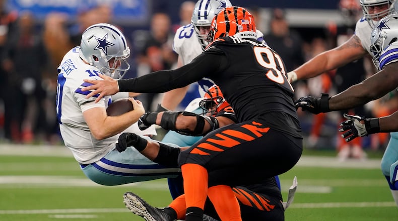 Cincinnati Bengals defensive end Sam Hubbard, bottom, sacks Dallas Cowboys quarterback Cooper Rush (10) along with Cincinnati Bengals defensive end Trey Hendrickson (91) during the second half of an NFL football game Sunday, Sept. 18, 2022, in Arlington, Tx. (AP Photo/Tony Gutierrez)