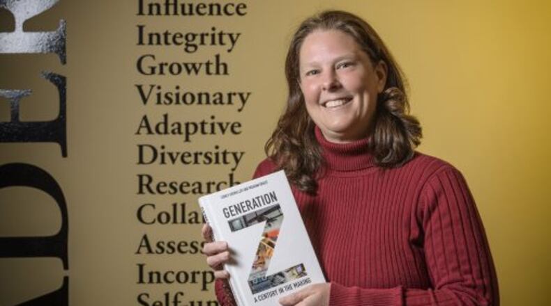 Corey Seemiller, Wright State University associate professor of leadership studies in education and organizations, with her book exploring the characteristics of Generation Z. (Photo by Erin Pence)