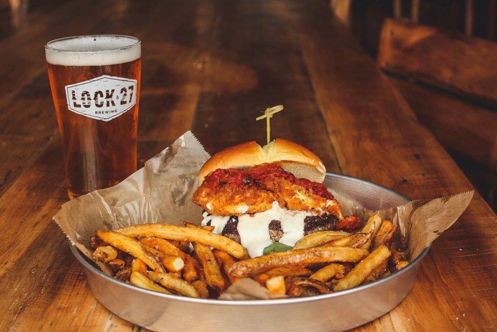 Lock 27's Taste of Italy Burger is topped with fried mozzarella, marinara, fresh basil, and creamy parmesan sauce. Source: Facebook