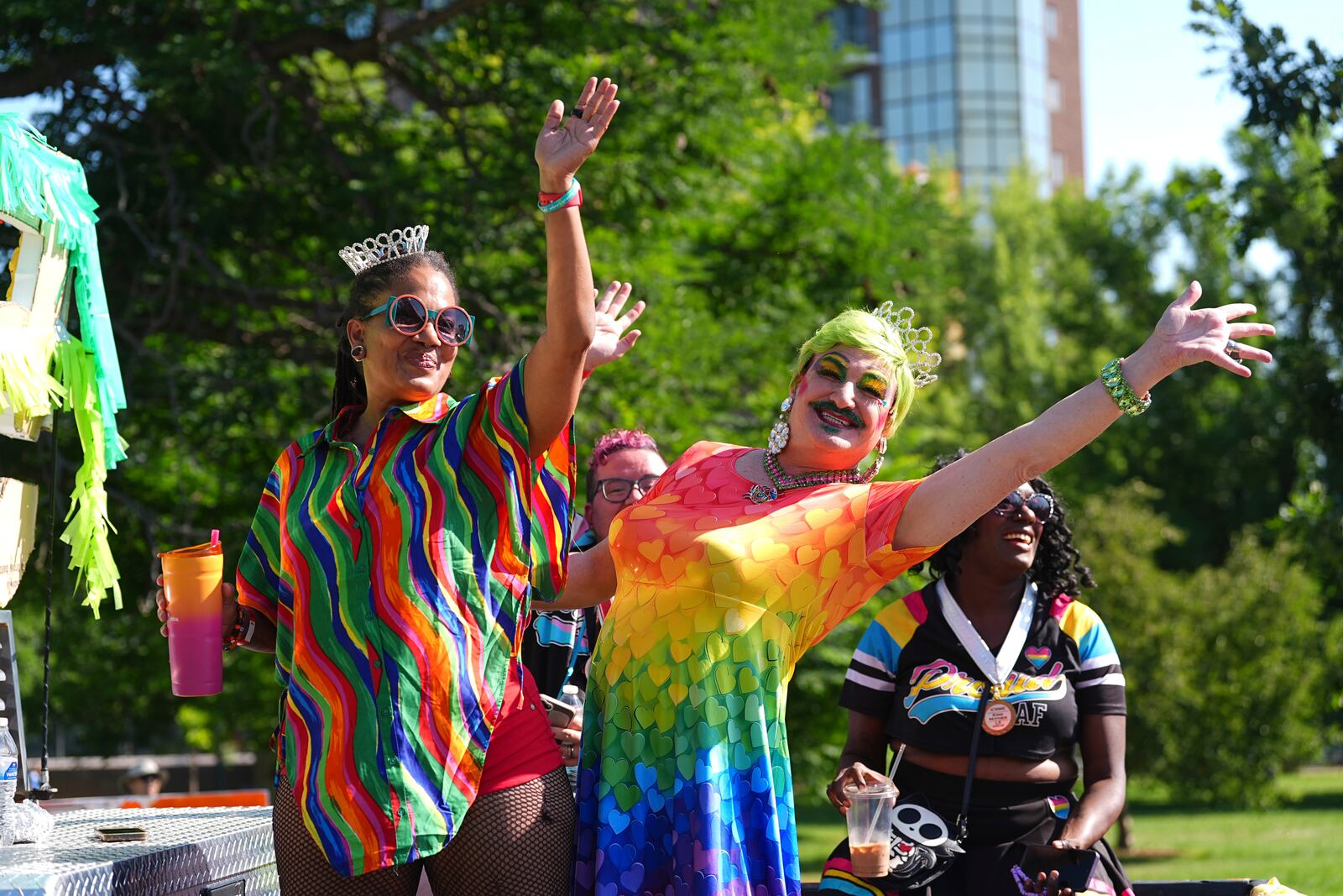 Participants wave as they ride on a float during a parade to celebrate pride month Sunday, June 29, 2025, in Denver. (AP Photo/David Zalubowski)