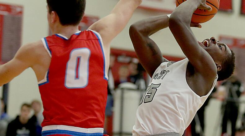 Lakota East guard Jarrett Cox shoots as Kings guard Gabe Stacy tries to block his attempt during their Division I sectional game at Lakota West on March 1. CONTRIBUTED PHOTO BY E.L. HUBBARD