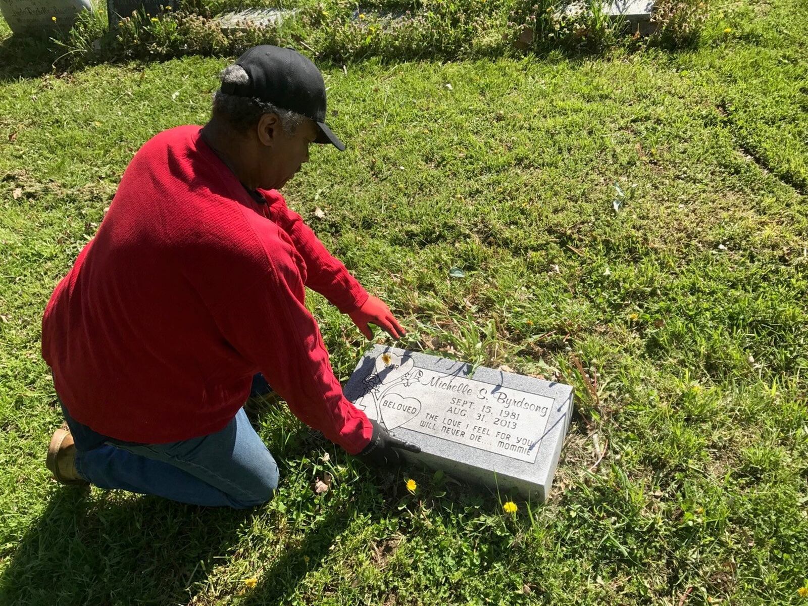 Volunteer Morton Branham, head of the Concerned Citizens of Greencastle Cemetery, attends to the grave of his niece Michelle Byrdsong. Tom Archdeacon/CONTRIBUTED