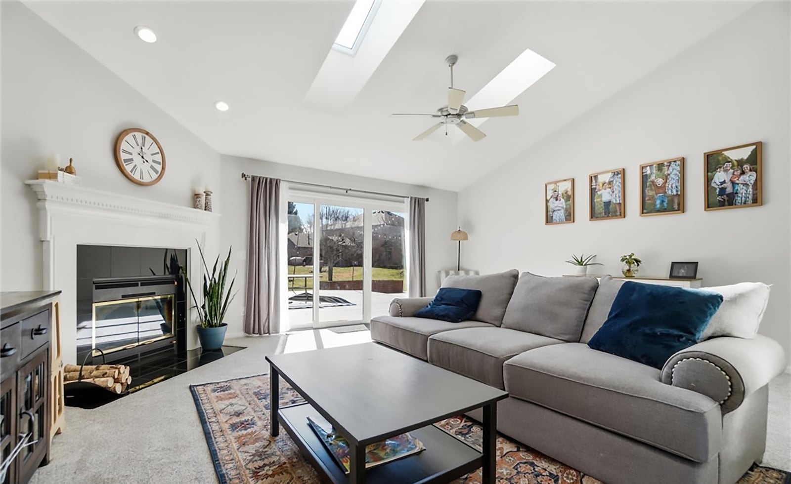 The living room has a vaulted ceiling and two skylights and a ceiling fan. It has newer neutral carpeting, a corner gas fireplace and a sliding glass doors opening to the deck. CONTRIBUTED