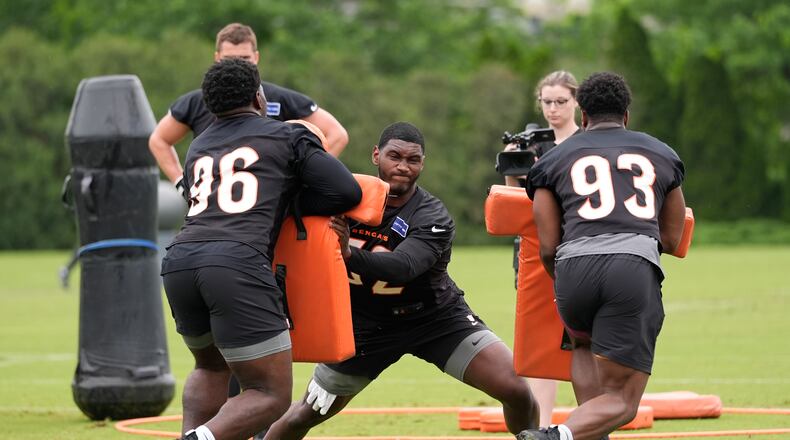 Cincinnati Bengals defensive end Cedric Johnson (52), center, with defensive ends Cam Sample (96) and Jeff Gunter (93) work a drill during the NFL football team's practice, Tuesday, May 14, 2024, in Cincinnati. (AP Photo/Carolyn Kaster)