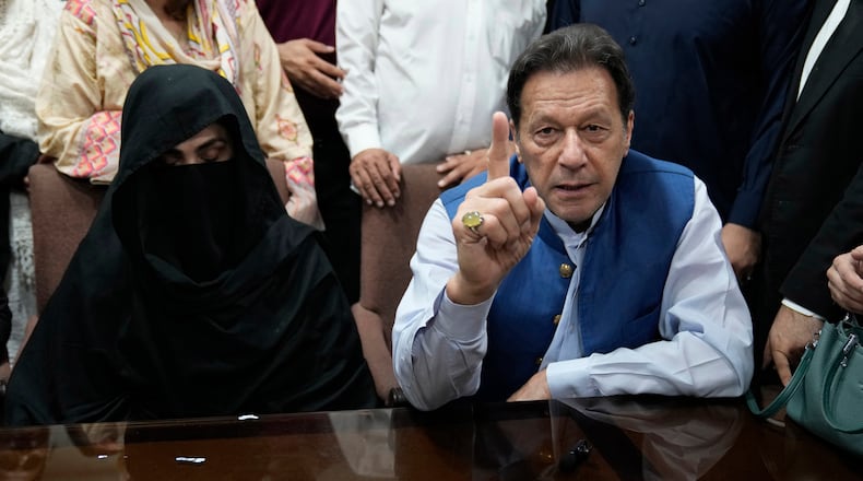 FILE - Pakistan's former Prime Minister Imran Khan, right, and Bushra Bibi, his wife, speak to the media before signing documents to submit surety bond over his bails in different cases, at an office of Lahore High Court in Lahore, Pakistan, on July 17, 2023. (AP Photo/K.M. Chaudary, File)
