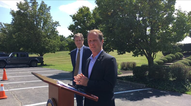 U.S. Rep. Chris Stewart, R-Utah, at a podium Tuesday outside the Hope Hotel at Wright-Patterson Air Force Base, with fellow Congressman Mike Turner, R-Dayton, looking on. THOMAS GNAU/STAFF