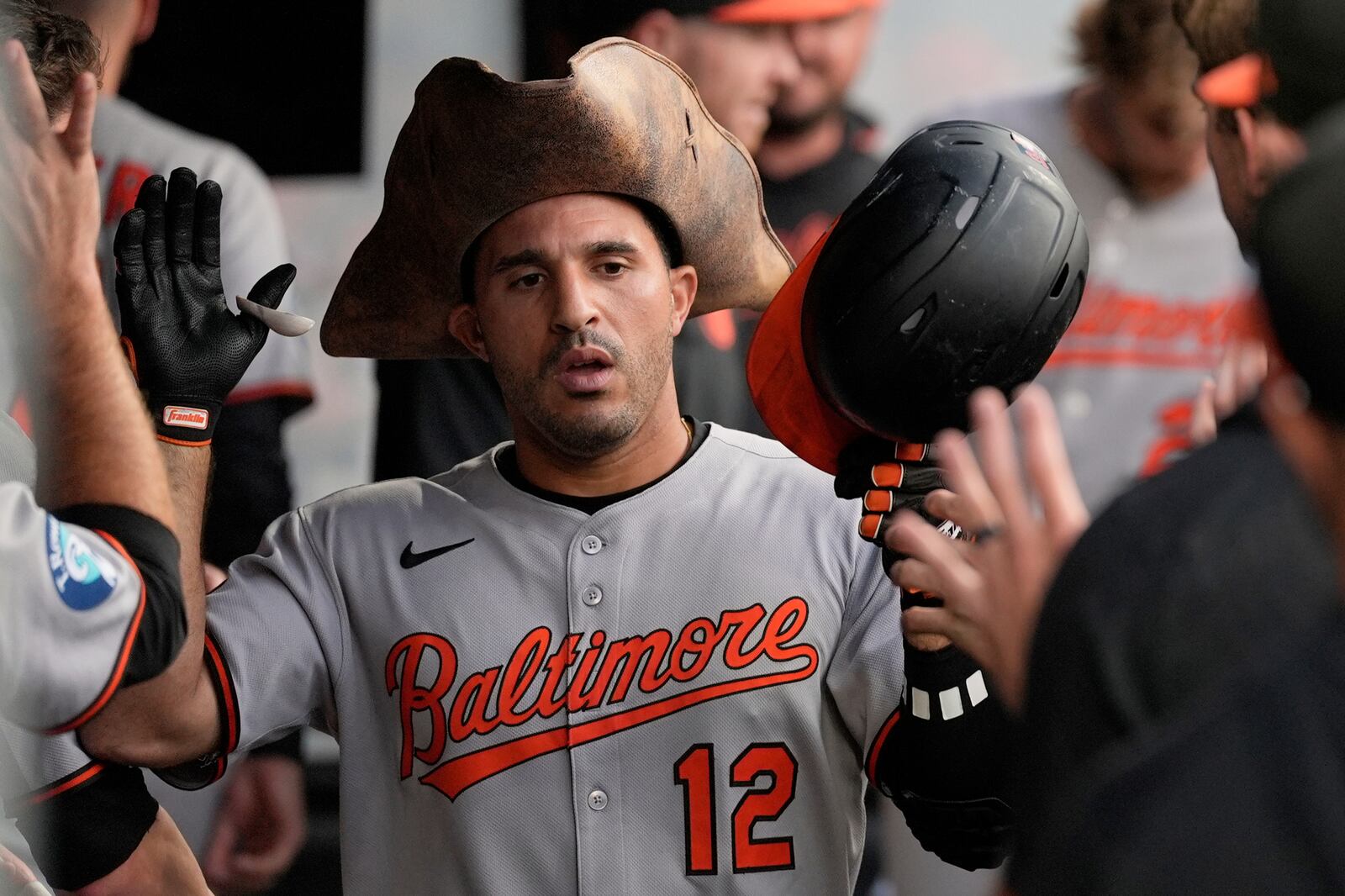 Baltimore Orioles' Ramon Laureano (12) is congratulated in the dugout after hitting a home run in the sixth inning of a baseball game against the Cleveland Guardians in Cleveland, Tuesday, July 22, 2025. (AP Photo/Sue Ogrocki)
