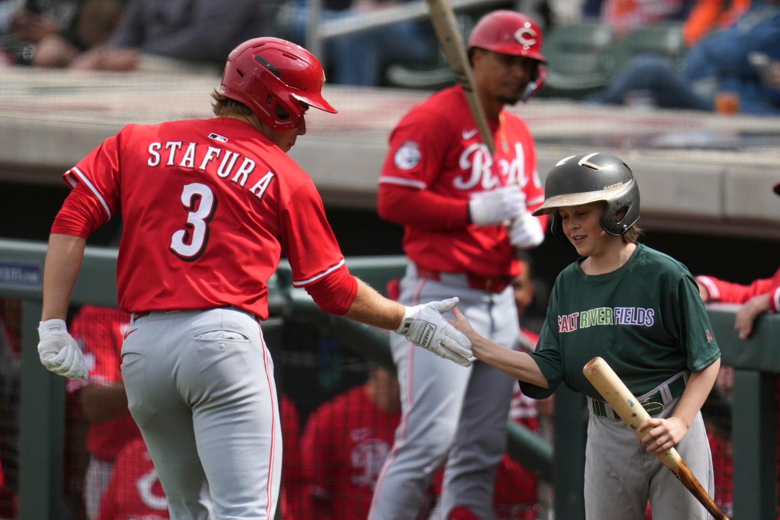 Cincinnati Reds' Sammy Stafura, left, celebrates after his home run against the Arizona Diamondbacks with a bat boy, right, during the sixth inning of a spring training baseball game Friday, March 14, 2025, in Scottsdale, Ariz. (AP Photo/Ross D. Franklin)