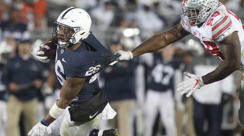 Ohio State’s Tyquan Lewis, right, tackles Penn State’s Saquon Barkley on Saturday, Oct. 22, 2016, at Beaver Stadium in State College, Pa. David Jablonski/Staff