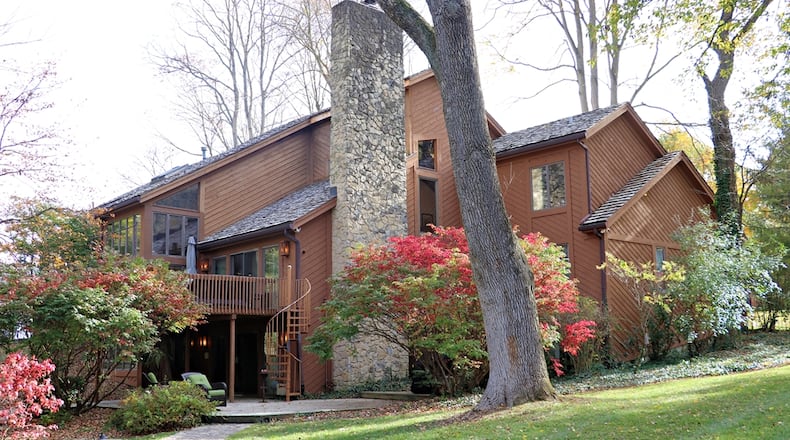 The 1.68-acre, four-parcel property is located along a nature reserve. Mature trees surround most of the property where a park-like back yard is surrounded by a metal fence. Wood-plank walkways weave their way to a wood patio, a spiral staircase to a wooden balcony deck, and to a concrete and paver in-ground pool with nearby pool house. Contributed photo by Kathy Tyler