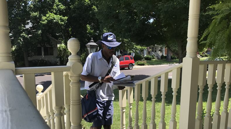Dasean Johnson, 34, has been a mailman in Kettering for six years. He says that nighttime hydration is essential in preparation for his daily 4.5-mile route. STAFF/GRANT PEPPER
