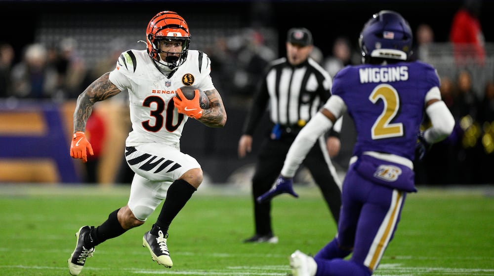 Cincinnati Bengals running back Chase Brown (30) runs with the ball against Baltimore Ravens cornerback Nate Wiggins (2) during the first half of an NFL football game, Thursday, Nov. 27, 2025, in Baltimore. (AP Photo/Nick Wass)
