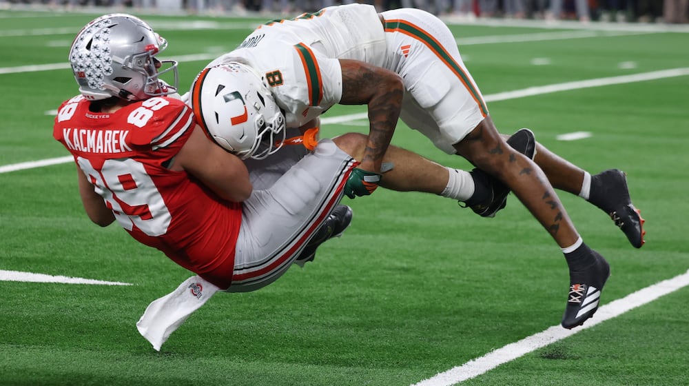 Miami defensive back Jakobe Thomas, right, makes a tackle on Ohio State tight end Will Kacmarek during the second half of the Cotton Bowl College Football Playoff quarterfinal game Wednesday, Dec. 31, 2025, in Arlington, Texas. (AP Photo/Gareth Patterson)
