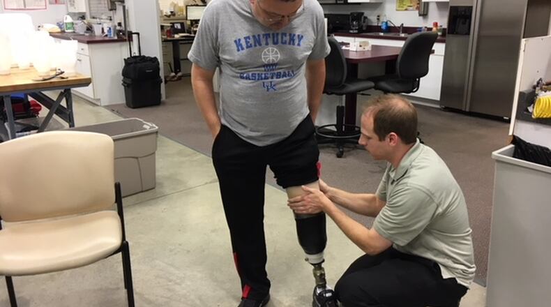 Michael Mullins, 50, a Harrison Twp. resident and patient of Dayton Artificial Limb, works with prosthetist Brad Poziembo on a limb adjustment. Mullins said his new lower leg has changed his life for the better. THOMAS GNAU/STAFF
