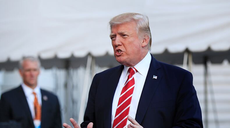 In this Oct. 7, 2017, photo, President Donald Trump speaks to reporters before leaving the White House in Washington for a brief stop at Andrews Air Force Base in Md., on his way to Greensboro, N.C. The Trump administration sent an immigration policy wish-list to Congress that includes overhauling the country's green-card system, hiring 10,000 more immigration officers and building a wall along the southern border.