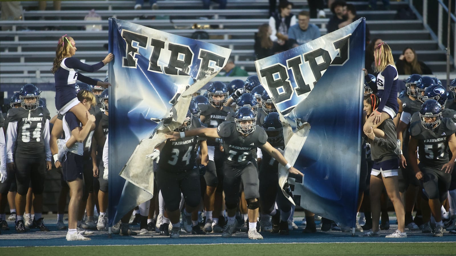 Fairmont's Griffin Chromick leads the team onto the field before a game against Springfield on Friday, Oct. 17, 2025, at Roush Stadium in Kettering. David Jablonski/Staff