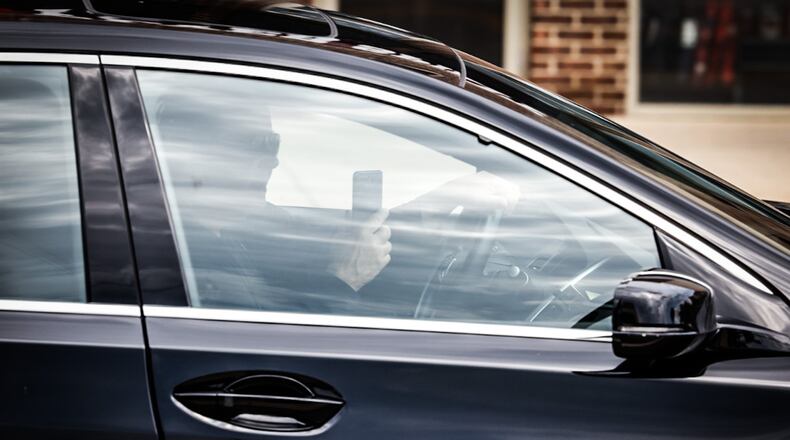 A driver on Brown Street appears to be using an electronic device Thursday Aug. 17, 2023. Police in Ohio have been issuing warnings only under a new, tougher distracted driving law for four months, but the warning period ends Oct. 5. JIM NOELKER/STAFF