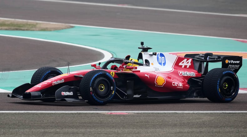 Britain's Lewis Hamilton waves to fans as he steers his Ferrari Formula One SF-26 at the Ferrari private test track, in Fiorano Modenese, Italy, Friday, Jan. 23, 2026. (AP Photo/Antonio Calanni)