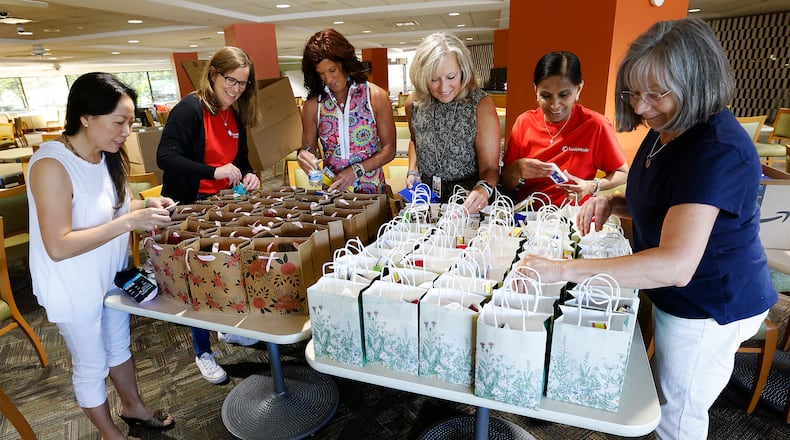 This team of ladies, From left, Tam Dowd, Community Gem Karen Westgerdes, Rene' Chase, Stephanie Singer, Rekha Vira and Pam Berg, pack street bangs at Lexis Nexis. The bags are made to help women on the streets and to combat sexual trafficking. MARSHALL GORBY/STAFF