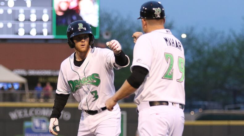 Dayton Dragons designated hitter Jay Schuyler fist bumps first base coach Kevin Mahar after getting a base hit during their 8-3 victory over the Great Lakes Loons on Thursday night at Fifth Third Field. CONTRIBUTED PHOTO BY MICHAEL COOPER