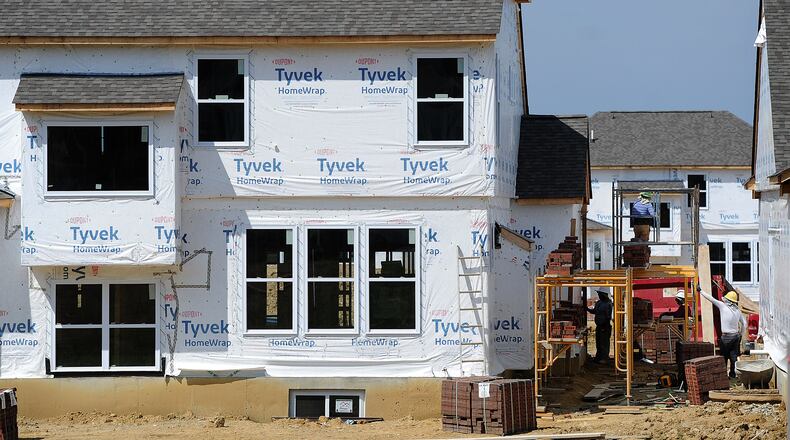 Construction crews work on one of the new homes that is being built in the Bellasera Subdivision in Sugarcreek Twp. MARSHALL GORBY\STAFF