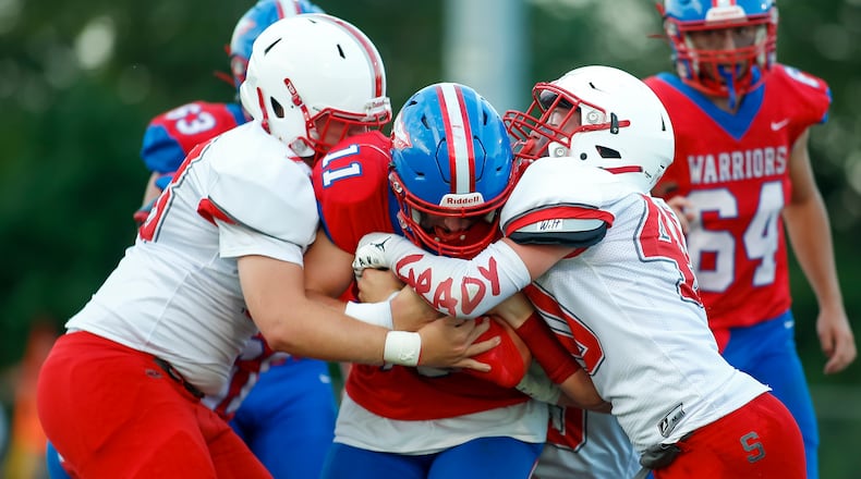 Southeastern High School's CJ Wilt (right) tackle a Northwestern player during a game last season in Springfield. Wilt wears an armband in honor of his cousin Grady, who passed away unexpectedly in 2018. CONTRIBUTED PHOTO BY MICHAEL COOPER
