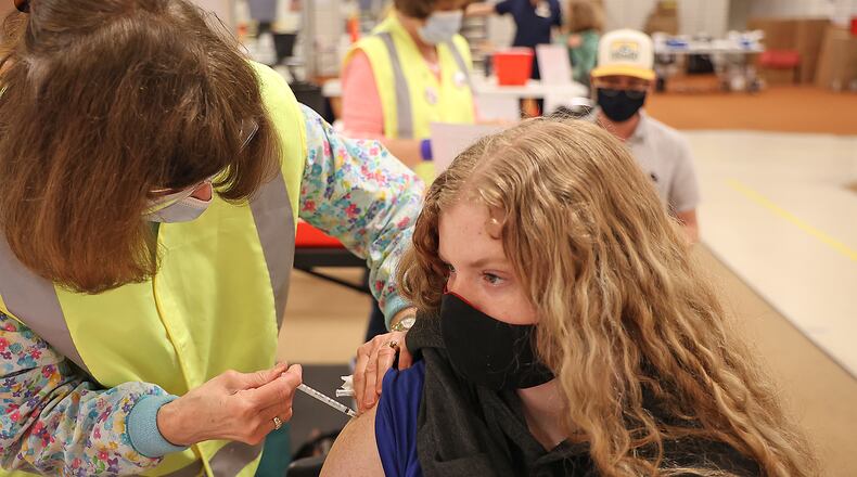 Cayla Moore, 16, gets her first COVID vaccine injection Tuesday at the Clark County vaccine distribution center at the Upper Vally Mall. BILL LACKEY/STAFF