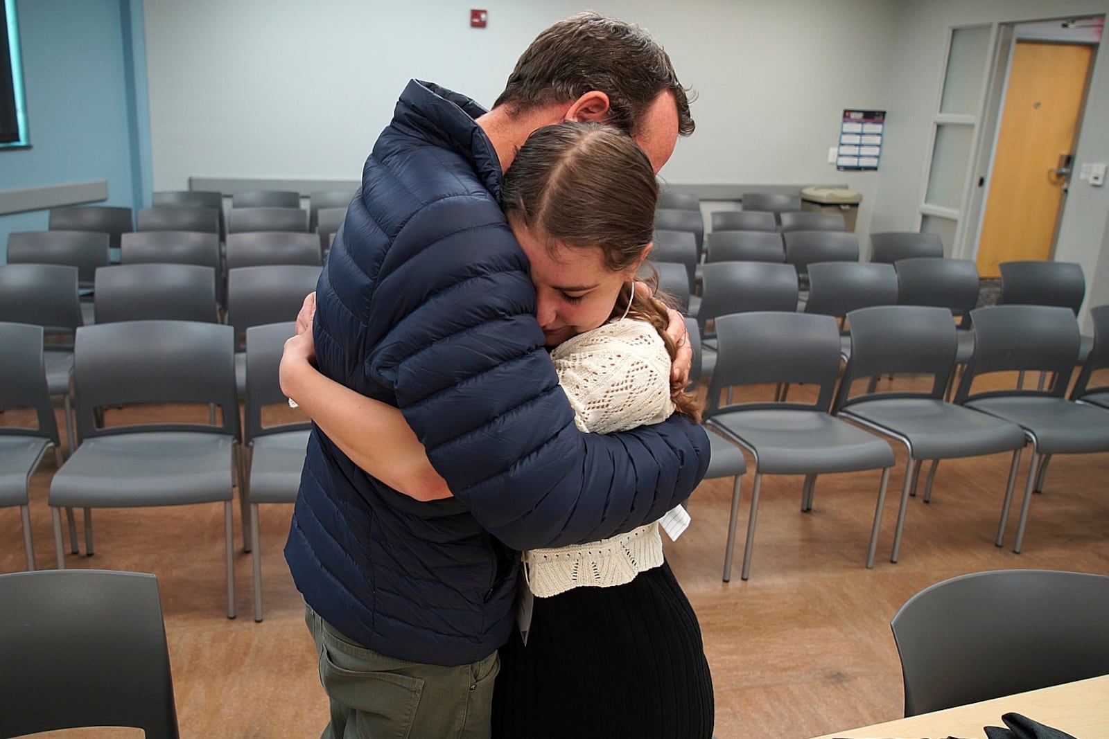 In this image taken from video, Kevin Lyman comforts his daughter, Lizzie, after her team from Atlanta's Midtown High School lost in the semifinals of the National High School Ethics Bowl, Sunday, April 23, 2025, in Chapel Hill, N.C. (AP Photo/Allen G. Breed)