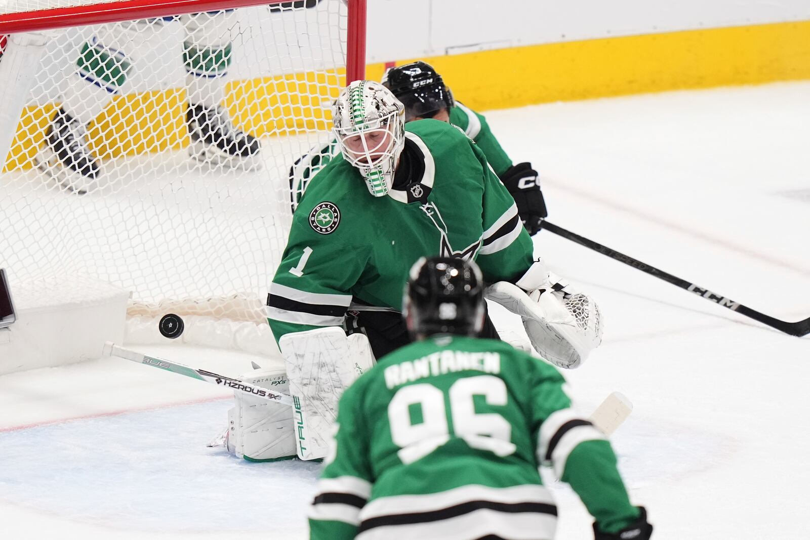 Dallas Stars goaltender Casey DeSmith (1) allows a goal scored by Vancouver Canucks' Kiefer Sherwood, not pictured, as Mikko Rantanen (96) looks on in overtime of an NHL hockey game in Dallas, Tuesday, April 8, 2025. (AP Photo/LM Otero)