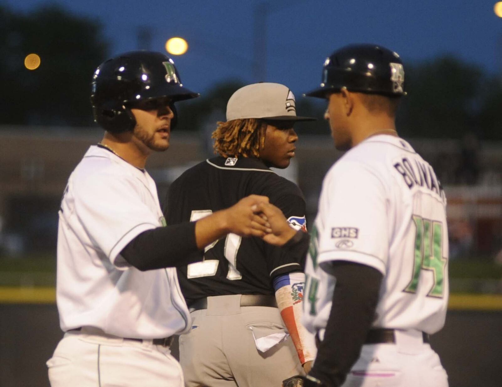 John Sansone of the Dragons (left) and manager Luis Bolivar meet in front of Lugnuts third baseman Vladimir Guerrero Jr. The Dragons hosted the Lansing Lugnuts (Blue Jays) at Dayton’s Fifth Third Field in a Midwest League Class A minor-league baseball game on Wednesday, April 19, 2017. MARC PENDLETON / STAFF