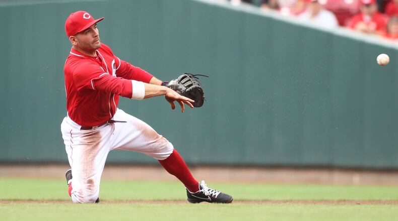 Reds first baseman Joey Votto throws to first for an out against the Pirates on Sunday, July 22, 2018, at Great American Ball Park in Cincinnati. David Jablonski/Staff