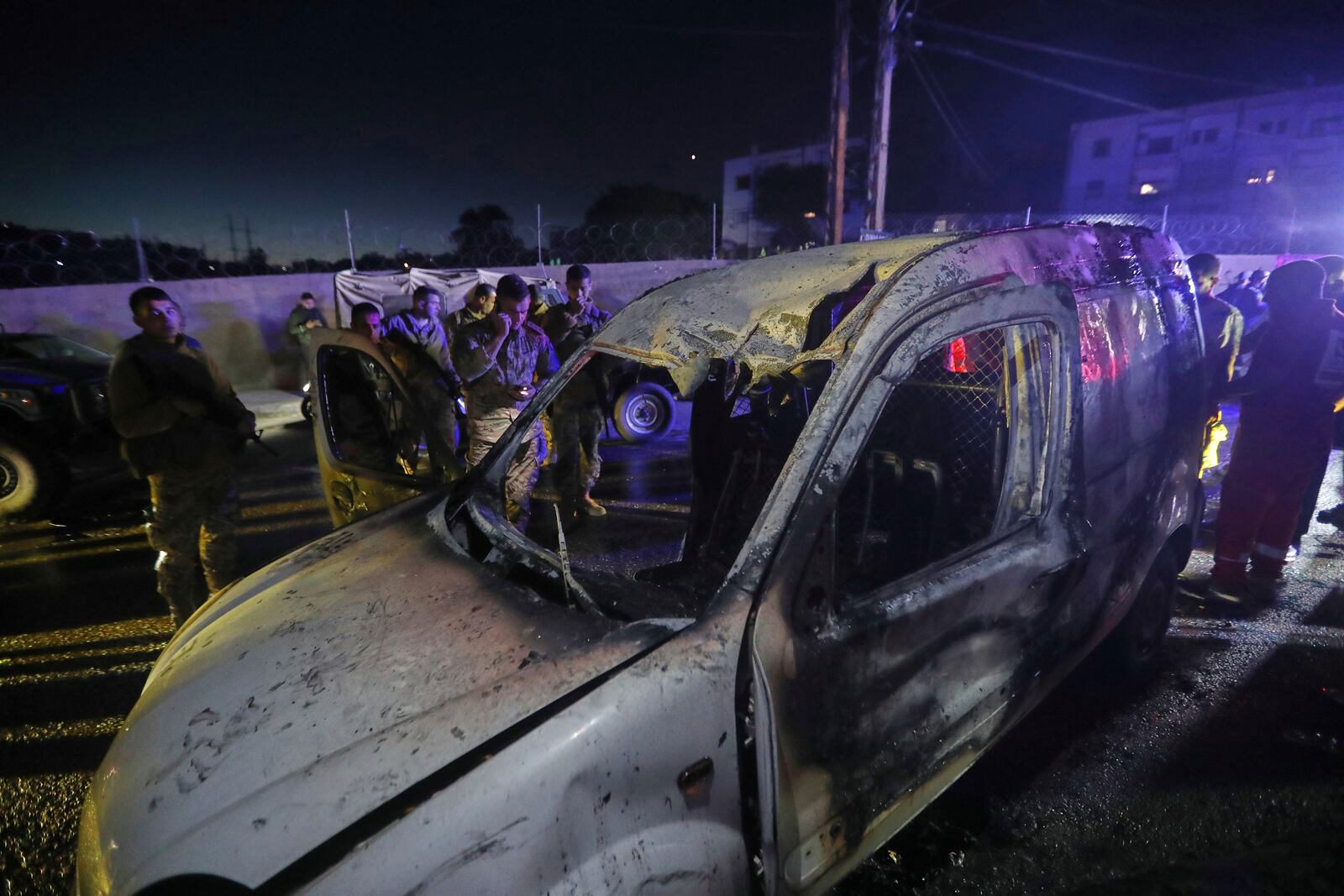 Lebanese army soldiers and rescue workers gather next of a damaged car after an Israeli strike, in the southern port city of Sidon, Lebanon, early Wednesday, May 7, 2025. (AP Photo/Mohammed Zaatari)