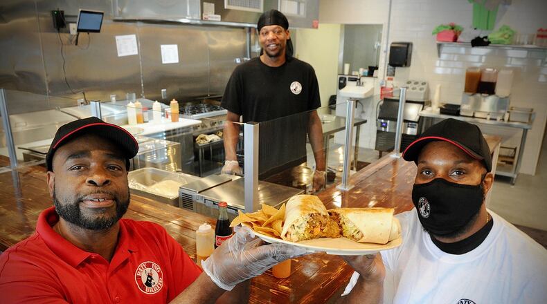 Co-Owners DeShawn Davis, on the left, and Walter Jones, on the right, pose with chief Denyan Blackmon with a King Burrito he made at the new Crazy King Burrito, located at 2624 Colonel Glenn Highway. MARSHALL GORBY\STAFF