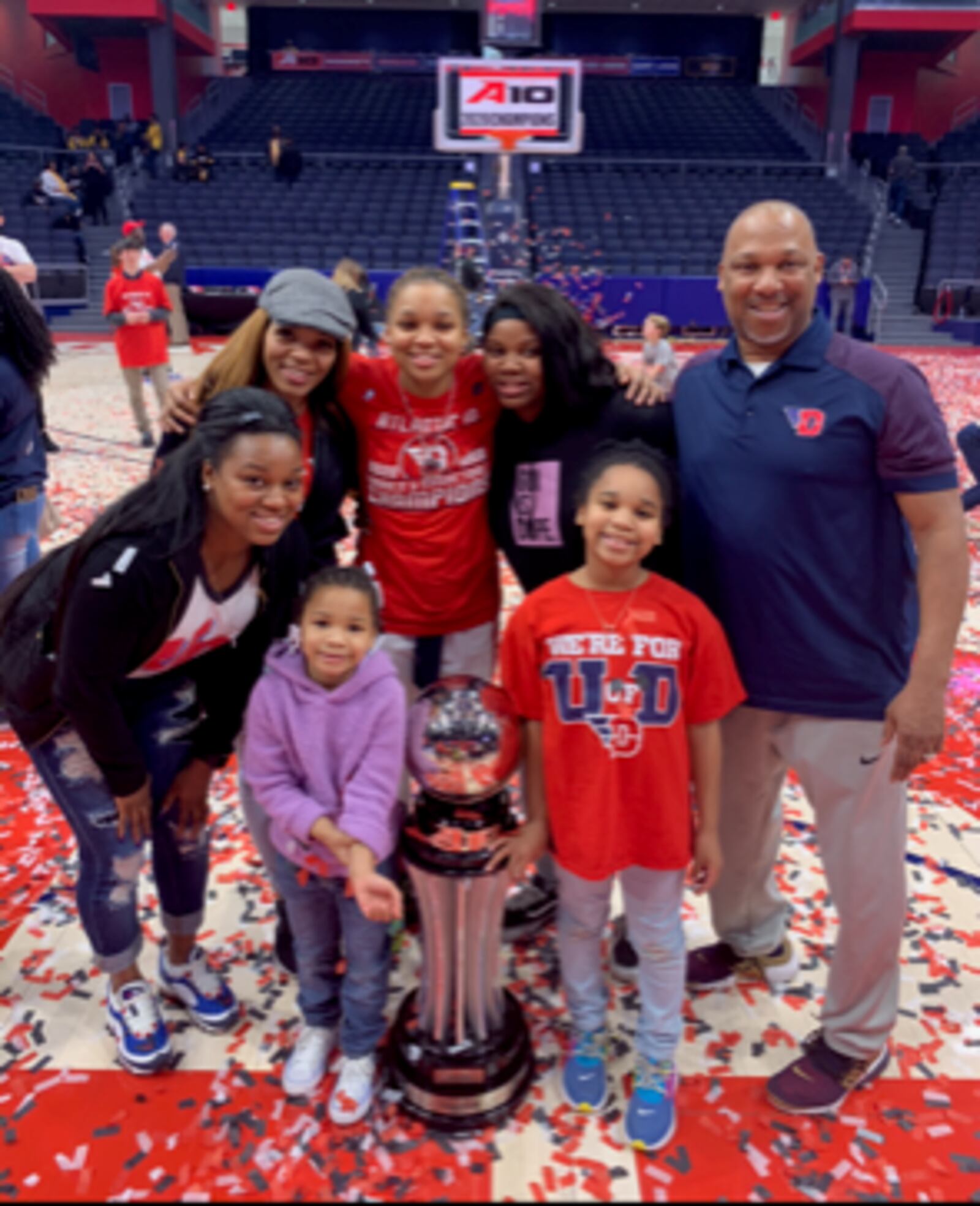 The Bradshaw Family at UD Arena after Flyers women won A-10 Tournament in March of 2020: (in front) Adrienne (age 5, in purple) and Aubrie (age 8, in red); (Back Row, left to right) Amari (leaning over) mom Kelley, Araion, Ariel and dad Eric.. CONTRIBUTED