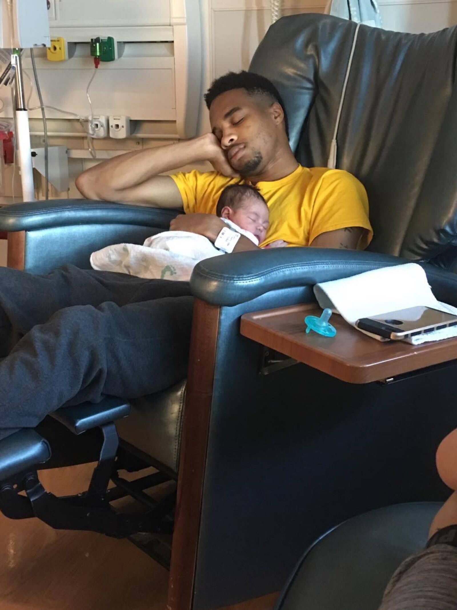 Taveon Glenn sleeps at Miami Valley Hospital with his newborn Amira.