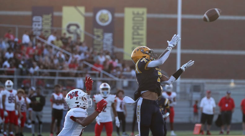 Springfield's Anthony Brown goes up for a first down catch as Wayne's Joshua Williams covers him during Friday's game. BILL LACKEY/STAFF