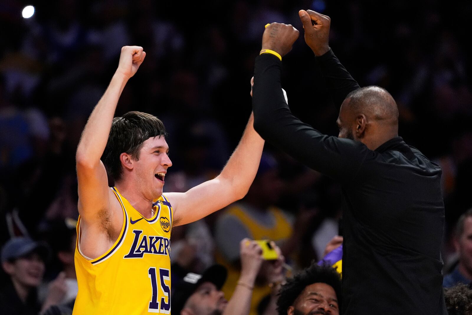 Los Angeles Lakers guard Austin Reaves, left, and forward LeBron James celebrate at the bench during the second half of an NBA basketball game against the Houston Rockets Friday, April 11, 2025, in Los Angeles. (AP Photo/Mark J. Terrill)